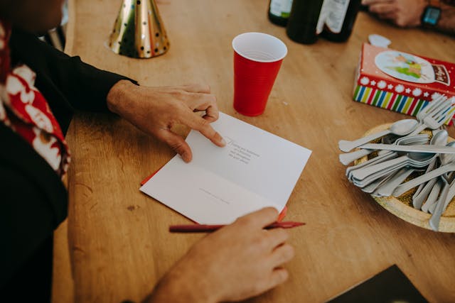 Un salarié qui écrit une carte de voeux de noël pour son parton